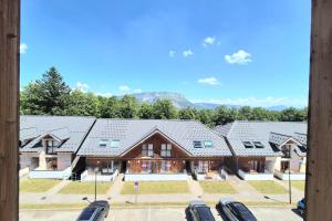 a row of houses with cars parked in a parking lot at Studio 2 pers avec accès piscine et sauna in Les Déserts +16 photos