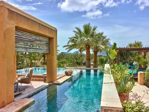 an infinity pool in a house with palm trees at Kasbah 2 in Sant Josep de sa Talaia