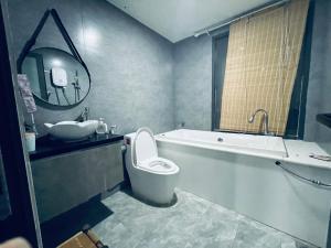 a bathroom with a sink and a toilet and a tub at Coral Homestay Phan Rang in Kinh Dinh
