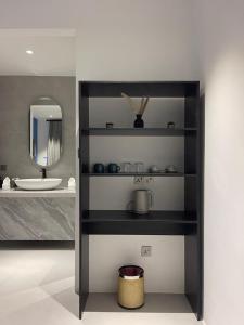 a shelf in a bathroom with a sink and a mirror at Velaa Dhigurah in Dhigurah