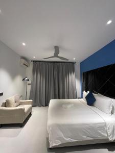 a bedroom with a large white bed and a couch at Velaa Dhigurah in Dhigurah
