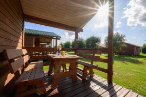 a wooden deck with a picnic table and benches at Domki i pokoje nad morzem U Izy Jarosławiec in Jarosławiec