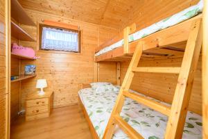 a bedroom with two bunk beds in a log cabin at Domki i pokoje nad morzem U Izy Jarosławiec in Jarosławiec