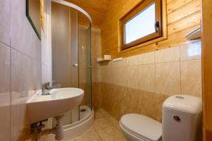 a bathroom with a sink and a toilet and a window at Domki i pokoje nad morzem U Izy Jarosławiec in Jarosławiec +29 photos