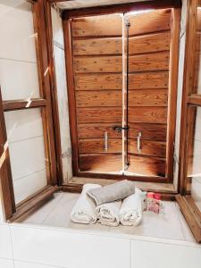 a bathroom with a wooden door and towels on a tub at Apartment Estera in Jelsa +17 photos