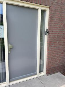 a sliding glass door on a brick building at Homestay Bij de Heldinnen in Helden