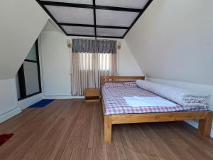 a bedroom with a bed and a window at BJ's Farmhouse in Nagarkot