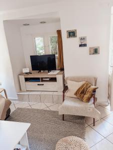 a living room with a tv and a chair at Apartment Estera in Jelsa