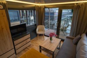 a living room with a couch and a tv and a table at Prague River Houseboats - Private Bay in Prague