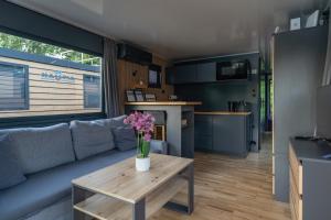 a living room with a couch and a table with flowers on it at Prague River Houseboats - Private Bay in Prague