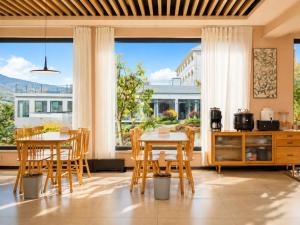 a kitchen with tables and chairs and a large window at Houshan Park House in Narat