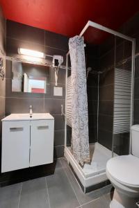 a bathroom with a shower and a toilet at Hipotel Paris Gambetta République in Paris +24 photos