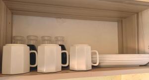 a row of white coffee mugs sitting on a shelf at Highway sunset in Namulanda +8 photos