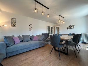 a living room with a couch and a table at Appartement RDC Chalet à 300m du lac de Gérardmer in Gérardmer