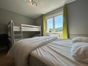 a bedroom with a large bed and a window at Appartement RDC Chalet à 300m du lac de Gérardmer in Gérardmer