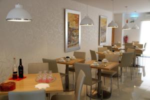 a restaurant with wooden tables and chairs and bottles of wine at Sea Garden Peniche in Peniche