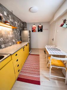 a kitchen with yellow cabinets and a table at Casa Family in Eforie Sud