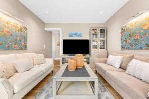 a living room with white furniture and a flat screen tv at Wild Wilderness in Schaalby