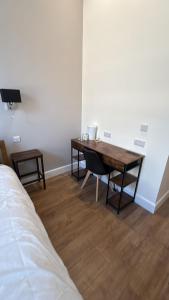 a room with a desk and a bed and a table at Super Nova Self-Service Hotel in Aberdeen
