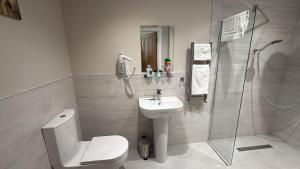 a bathroom with a toilet and a sink and a shower at Super Nova Self-Service Hotel in Aberdeen