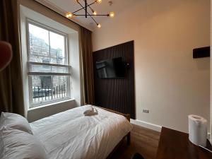 a bedroom with a bed and a tv and a window at Super Nova Self-Service Hotel in Aberdeen
