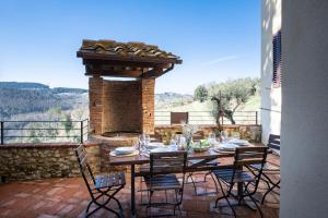 a table and chairs on a patio with a fireplace at Agriturismo Poggio Nardini in Montelupo Fiorentino