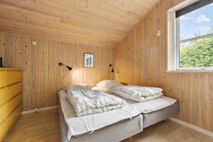 a bedroom with a bed in a wooden wall at 8522-Grenaa-Nobilisvej-15 in Grenå