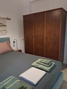 a bedroom with a bed with a wooden cabinet at Asprocyclia House in Kalymnos