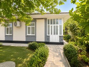 a house with a white door and a yard at Apartment Casa de Bruja in Drochia