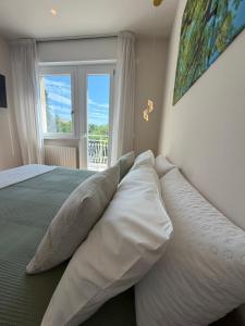 a bedroom with a bed with pillows and a window at Pratelli B&B in Saludecio