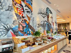 a buffet line with a mural of a woman at Nha Trang Oceanview Suites in Nha Trang