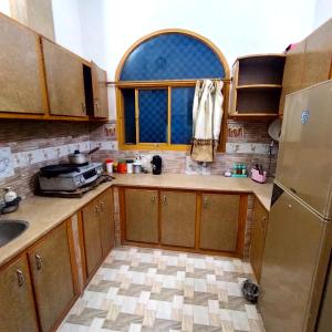a kitchen with a sink and a refrigerator at Whispering Fields in Abbottabad