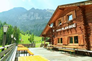 a wooden building with tables and benches on a deck at Rifugio Plan Boè in Livinallongo del Col di Lana