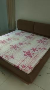 a bed with pink flowers on it in a room at Potion's Villa - Shimla in Shimla +3 photos