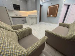 a living room with two chairs and a kitchen at Potion's Villa - Shimla in Shimla
