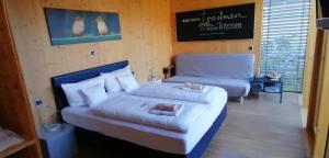 a bedroom with a large bed and a couch at HOTEL SPATZENNEST Vogelsberg in Herbstein