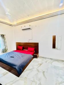 a bedroom with a large bed with red pillows at Hotel Jazz Suit Villa in Agra