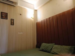 a bedroom with a bed with a wooden headboard at SH Homestay in Tezpur