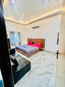 a bedroom with a bed with pink pillows at Hotel Jazz Suit Villa in Agra