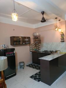 a kitchen with a black refrigerator and a counter at SH Homestay in Tezpur