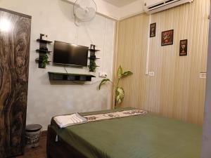 a room with a bed and a flat screen tv at SH Homestay in Tezpur