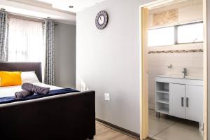 a bedroom with a bed and a sink and a window at Red Pillar in Maseru +14 photos