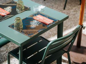a green table with a chair in front of it at ibis Styles Lens Centre Gare in Lens