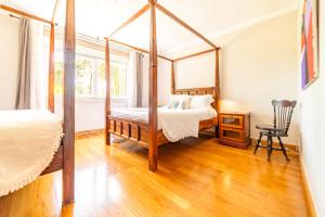 a bedroom with a four poster bed and a chair at Villa Praia e Floresta in Aroeira +79 photos