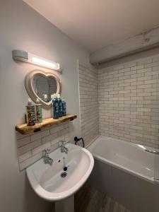 a bathroom with a sink and a bath tub at Bewerley Hall farm in Harrogate