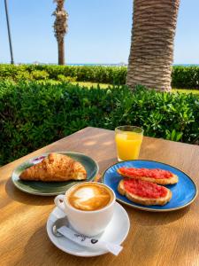 a table with a cup of coffee and a plate of food at Malvarrosa Beach Rooms in Valencia