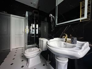 a black and white bathroom with a sink and a toilet at Willa Ingeborg in Międzyzdroje +20 photos