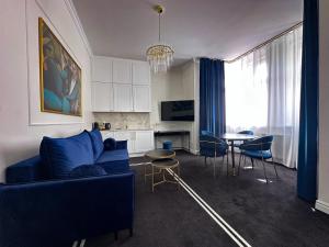 a living room with a blue couch and a table at Willa Ingeborg in Międzyzdroje
