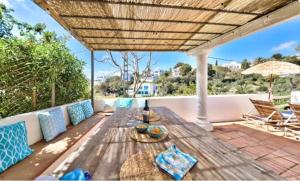 a patio with a wooden table and chairs at Villa Granadella in Jávea