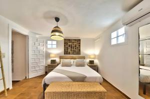 a white bedroom with a bed and a table at Villa Granadella in Jávea